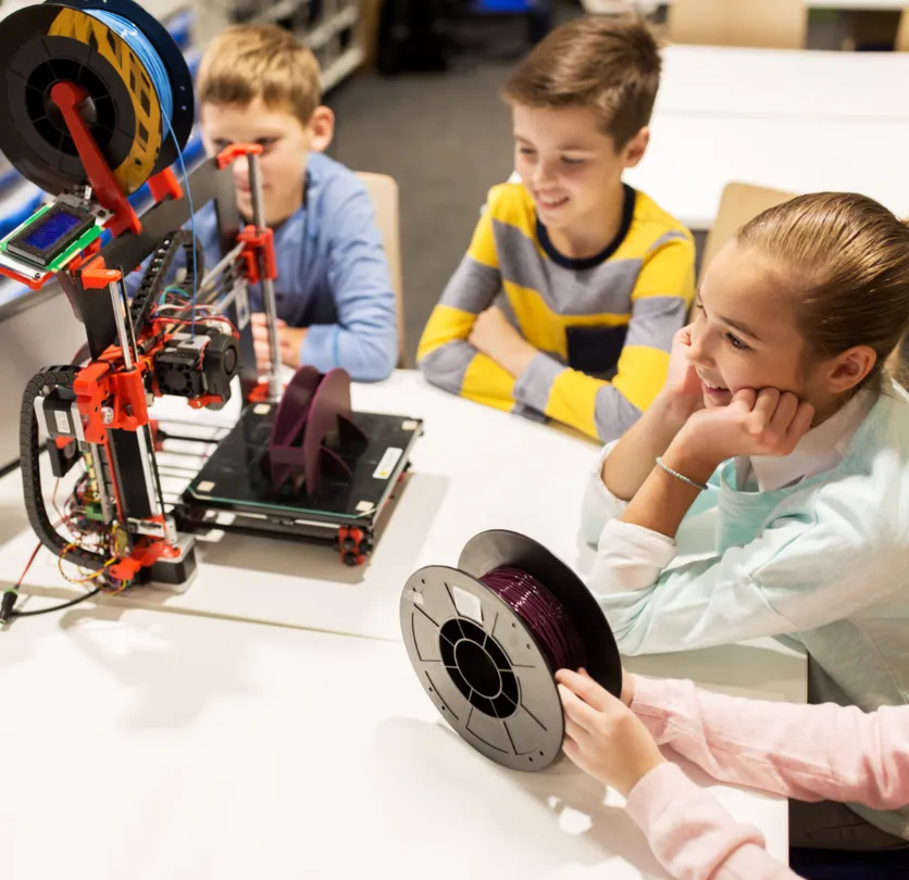 Children watching a 3D printer print their designs in class